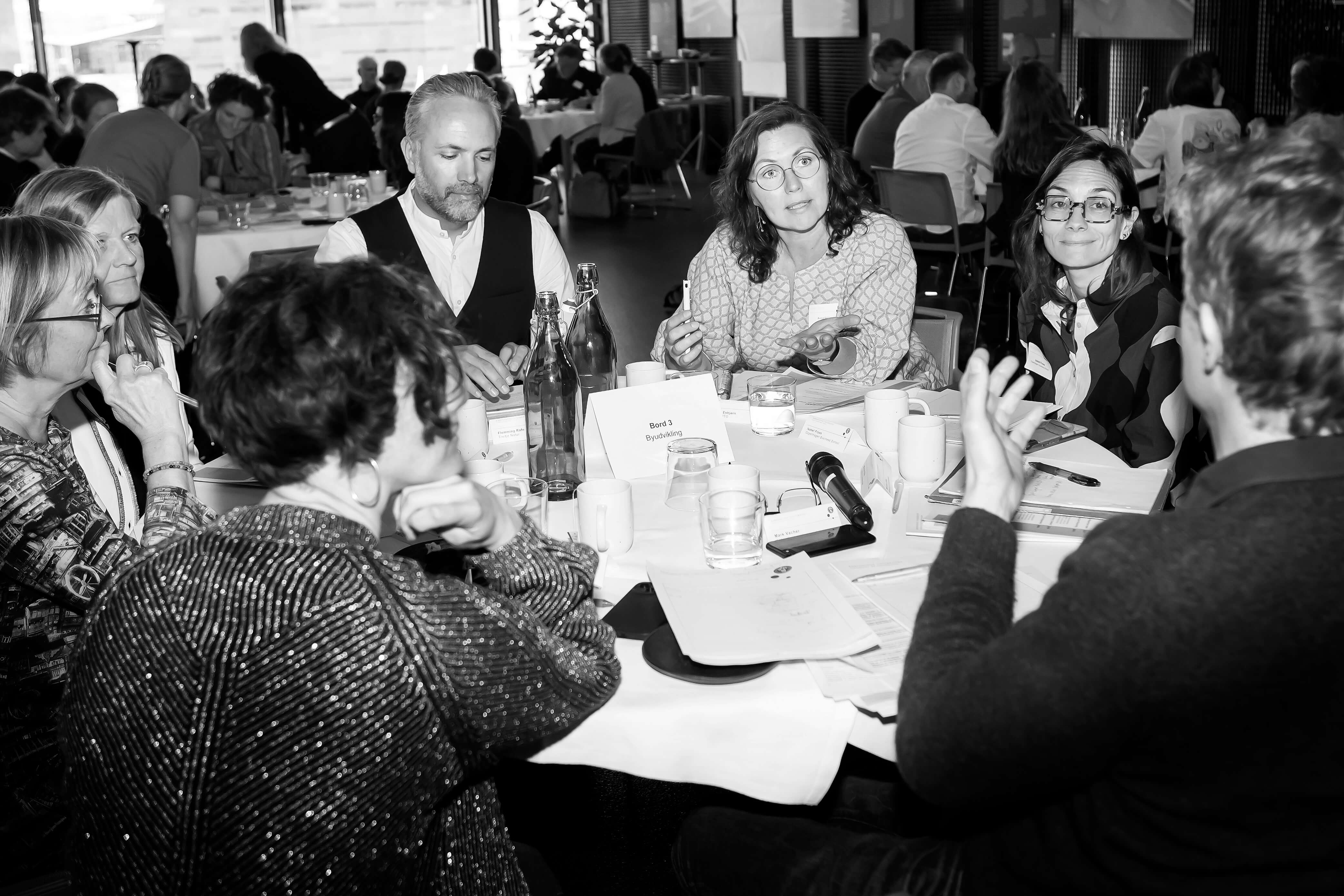 People seated around a table, engaged in collaborative workshop activities and discussion